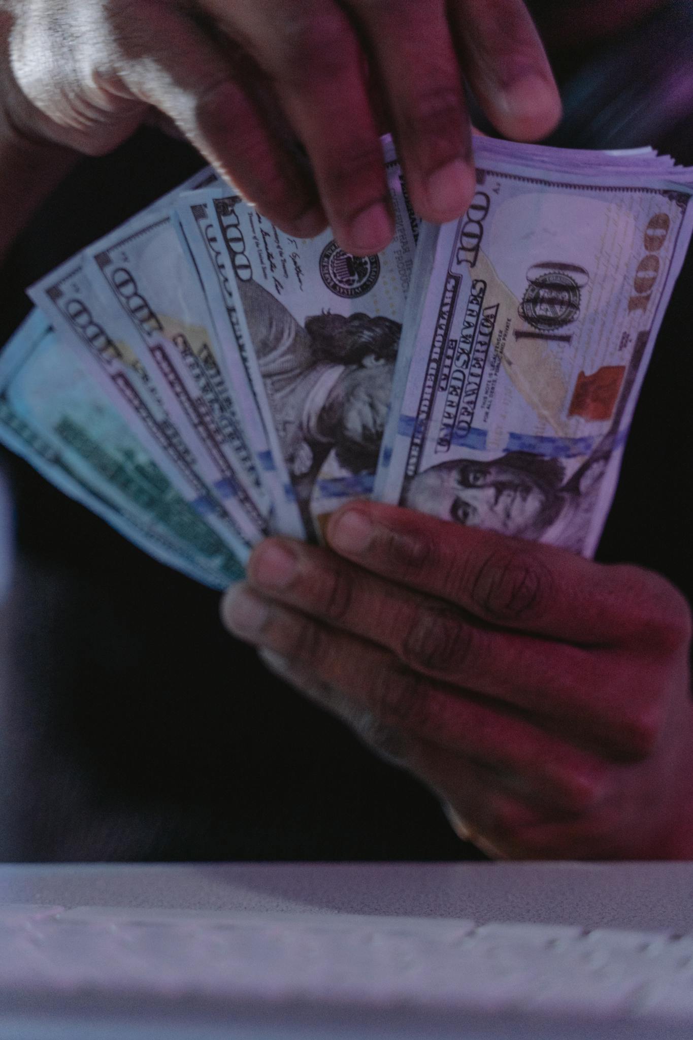 A detailed close-up of hands holding and fanning US dollar bills, showcasing financial concepts.